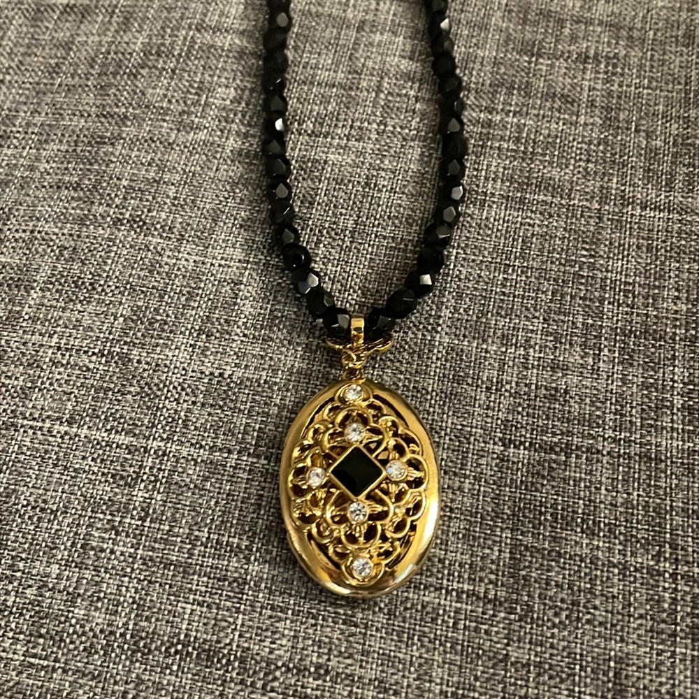 Vintage 1928 black, gold and rhinestone locket on black bead necklace.